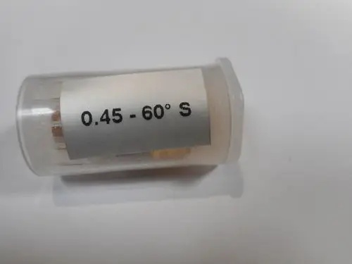 Transparente Kunststoffhülse mit einer Düse von Remeha, beschriftet mit "0.45 - 60° S". Innerhalb sind verschiedene Teile zu erkennen.